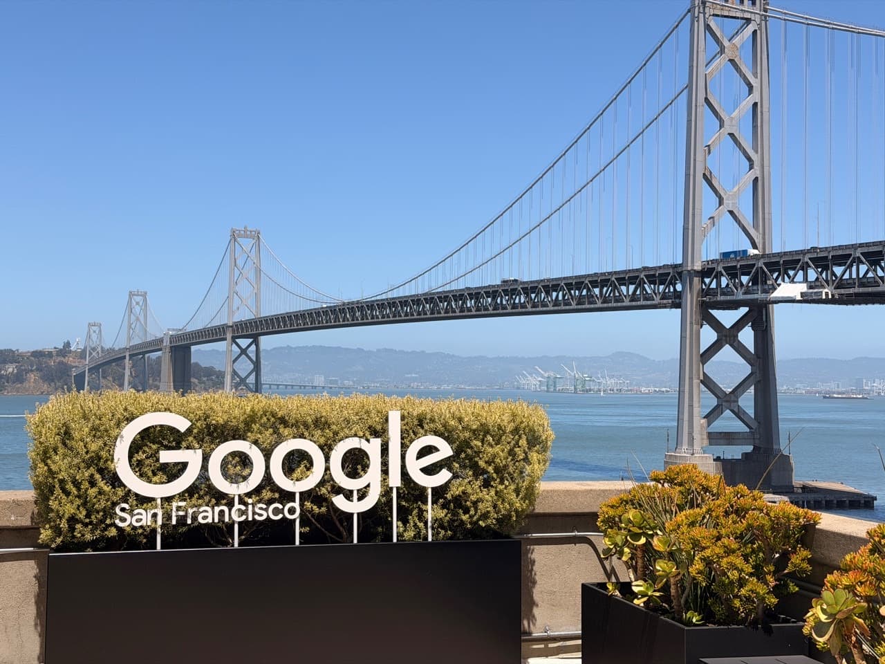 Google San Francisco office sign with the Bay Bridge behind it